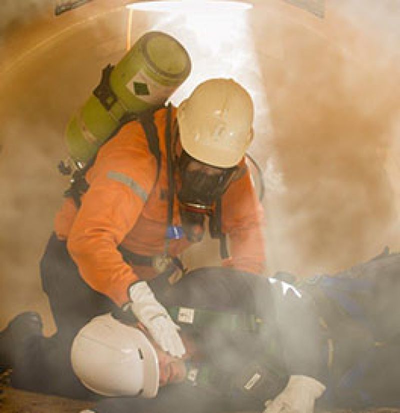 Image of worker attending to unconscious worker during a gas leak