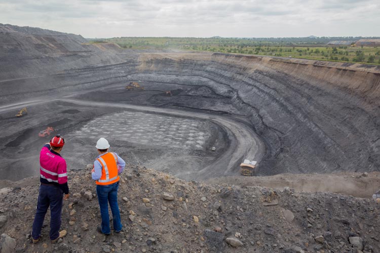 coal workers overlooking open-cut coal mine pit